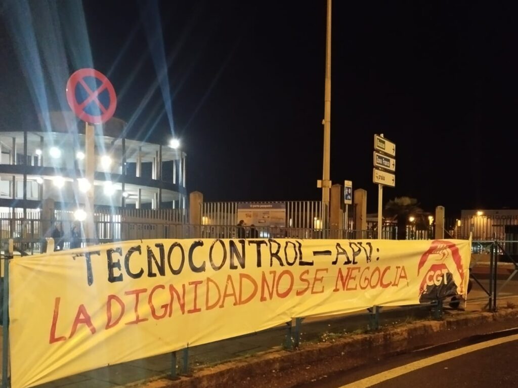 Pancarta a carón da carretera de acceso ao Porto de Vigo coa mensaxe "Tecnocontrol - APV: La dignidad no se negocia"